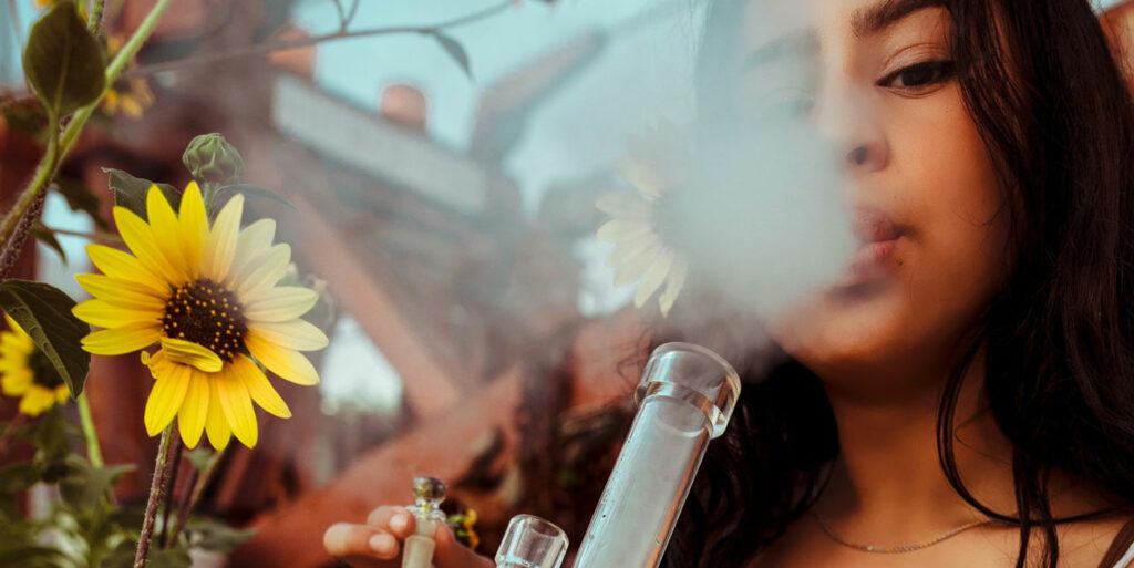 Woman smoking cannabis flower in a bong