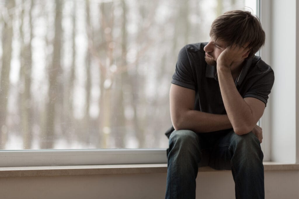 Ein Mann, der sich den Kopf hält, symbolisiert die Wirkung von CBD gegen Depressionen.