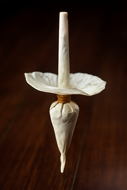 CBD Joint in Tulpenform, fortgeschrittene Drehtechnik auf dunklem Hintergrund